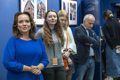 Kilka osób na zdjęciu ze wzrokiem skierowanym w różnych kierunkach. Na pierwszym planie kobieta z brązowymi, długimi włosami i jasno granatowej sukience, fot. B.Motyka 