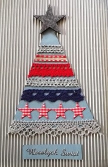 Kartka świąteczna. Na srebrnym tle wycięty prosty, trójkątny niebieski kształt choinki. Na trójkącie umieszczone równoległe poziome pasy z szarej, granatowej i czerwonej koronki. Na czubku choinki szara gwiazda.