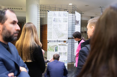 Na zdjęciu grupa kilku oosób zgromadzona przy jednej z wyróżnionych prac. Rozmawiają ze sobą,