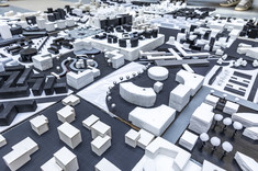 Zbliżenie na kilka biało-czarnych makiet. Każda z makiet jest wykonana na podstawie kwadratowej o boku 30 cm.