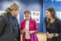 Na pierwszym planie dwie kobiety i mężczyzna podczas rozmowy, uśmiechają się.