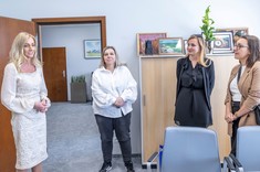 Osoby zgromadzone podczas podpisania umowy podczas swobodnej rozmowy. Cztery kobiety elegancko ubrane stoją skierowane twarzami do siebie, uśmiechają się.