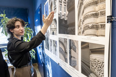 Młoda kobieta wskazuje dłonią fragment prezentowanego zdjęcia.