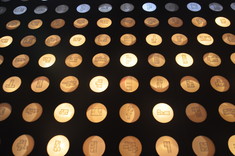 Na czarnym tle rozmieszono w równych odstępach niewielkie koła. Każde koło ma narysowany plan innego mieszkania i jest podświetlone ciepłym światłem.