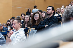 Zbliżenie na uczestników wykładu siedzących w rzędach.